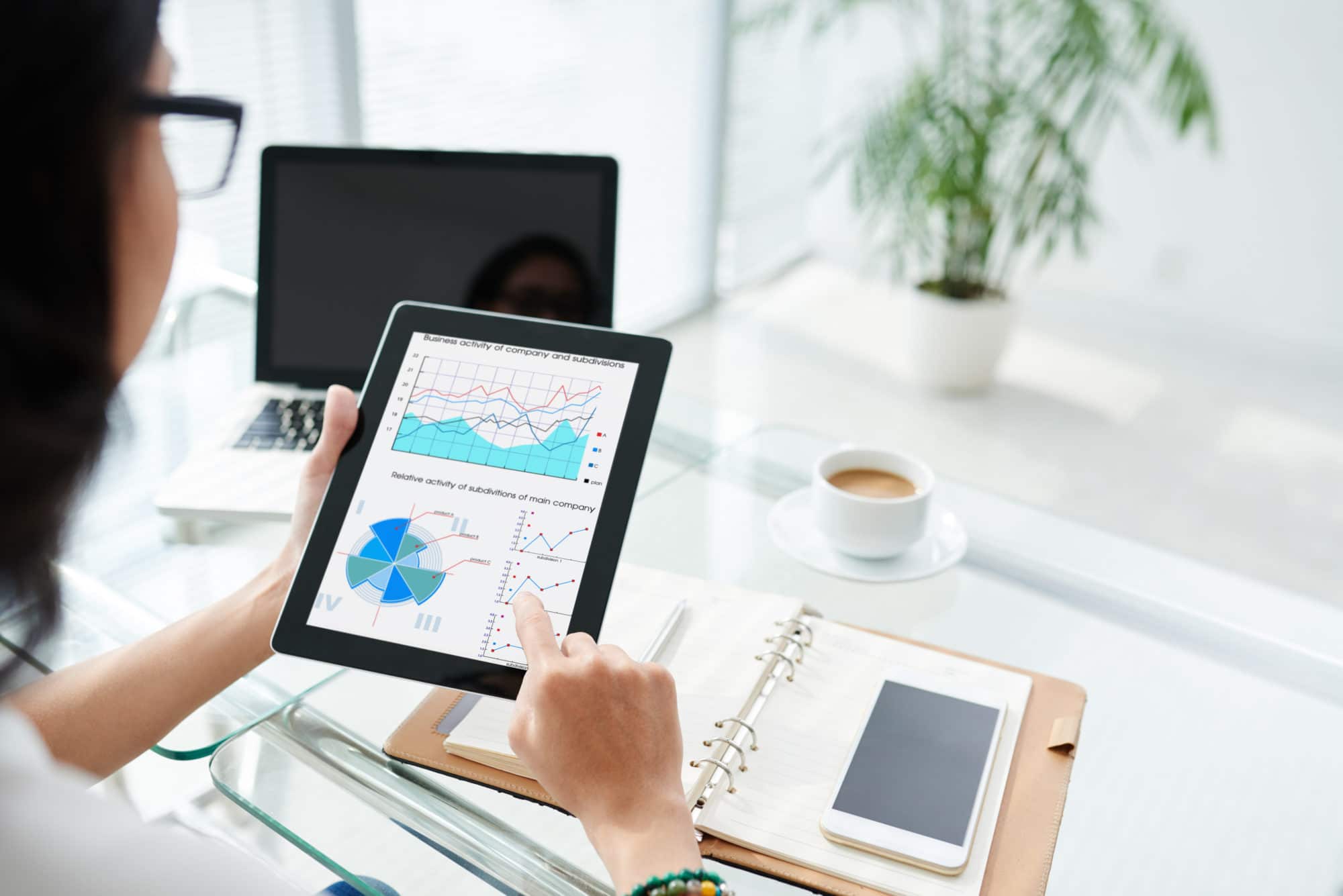 Business lady examining diagram on her tablet computer