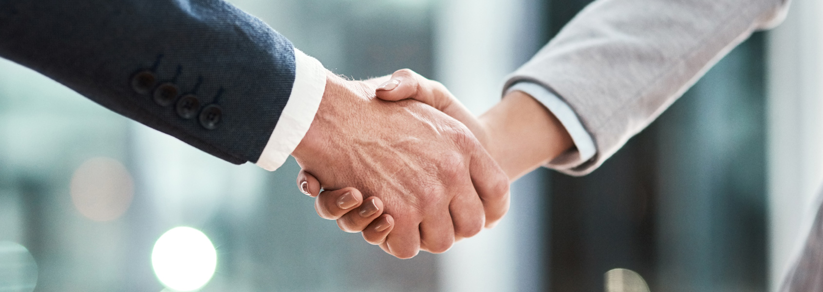 hand shake between two men for Qualifacts and California County Partnership
