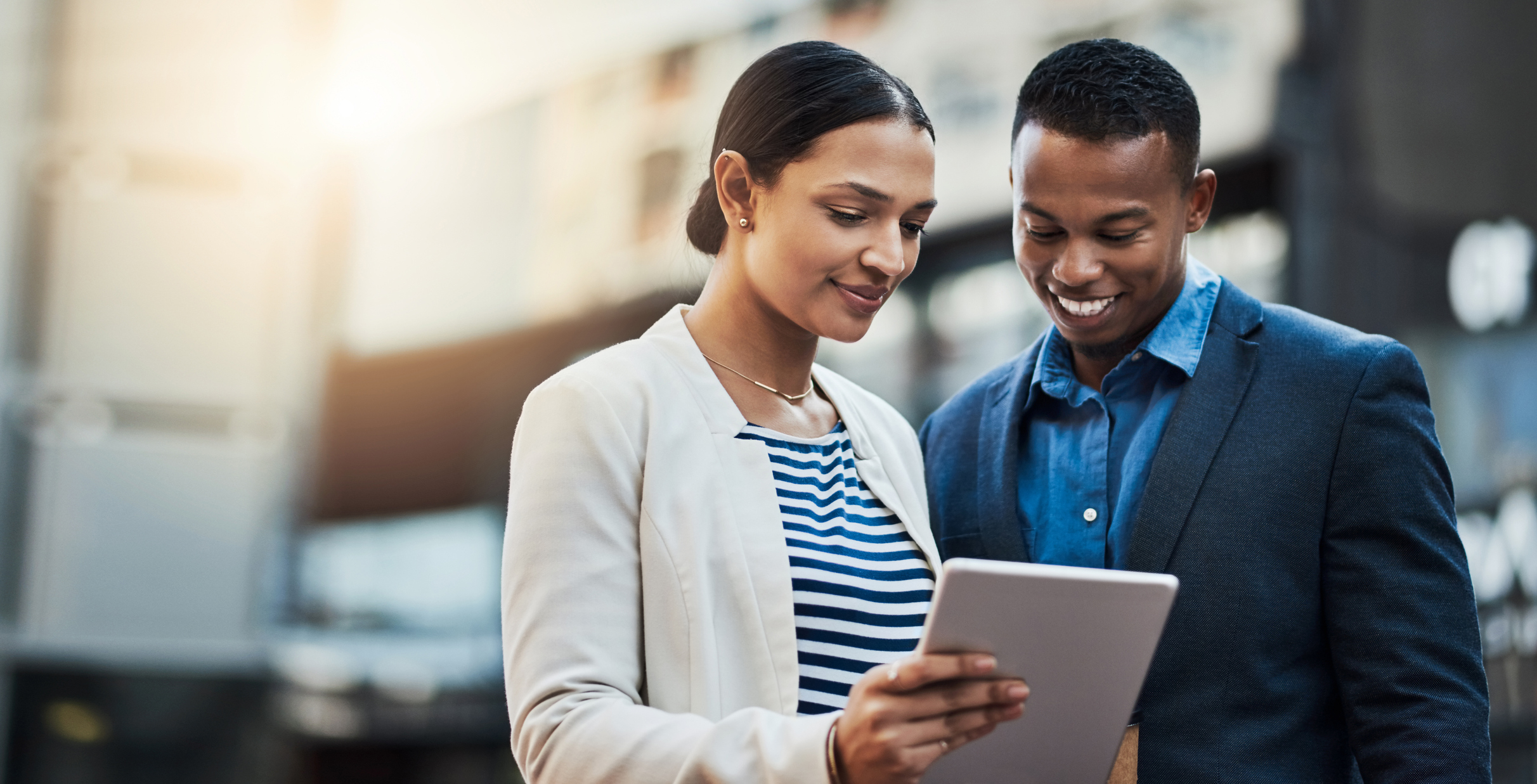 Shot of two businesspeople using a digital tablet in the city