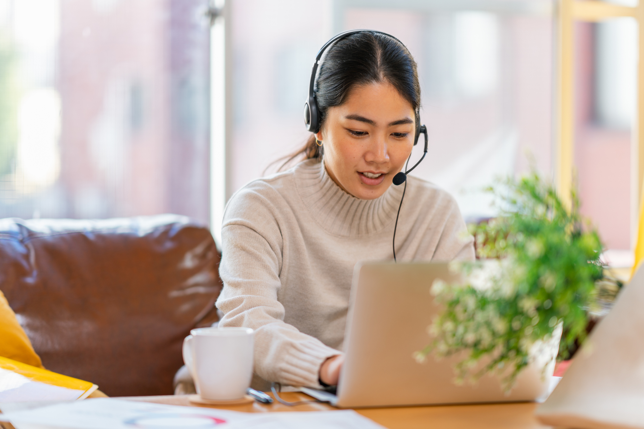 woman using laptop and taking 988 call with headset