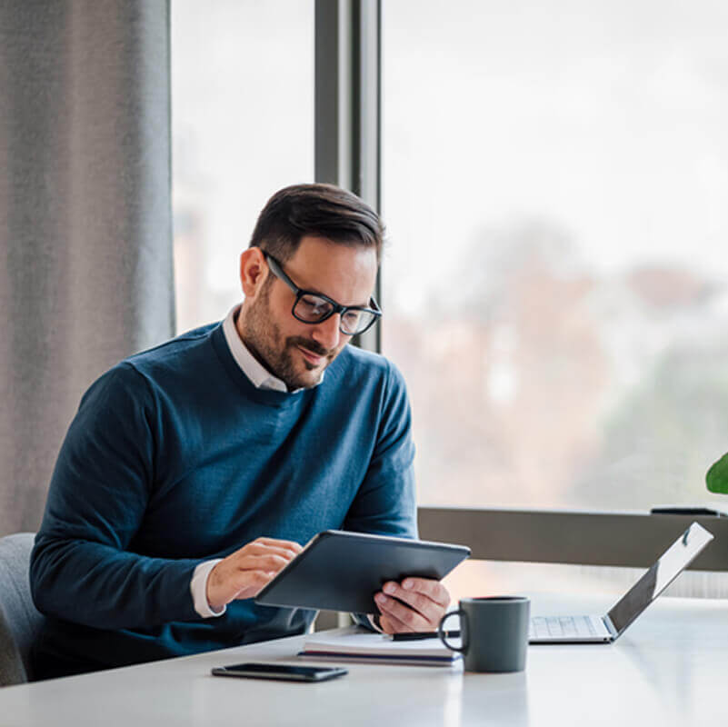 A man using a tablet and a laptop