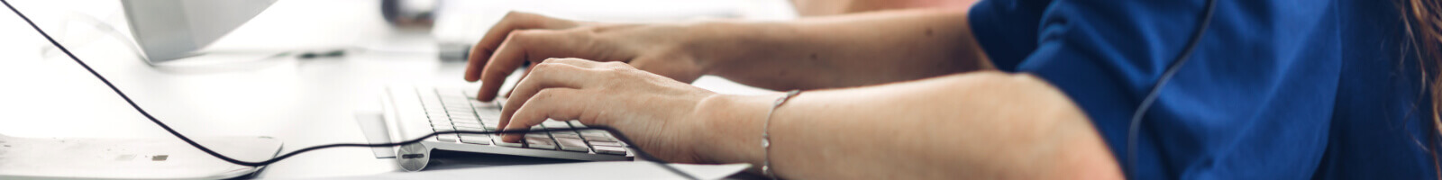 Close up of hands typing on a keyboard