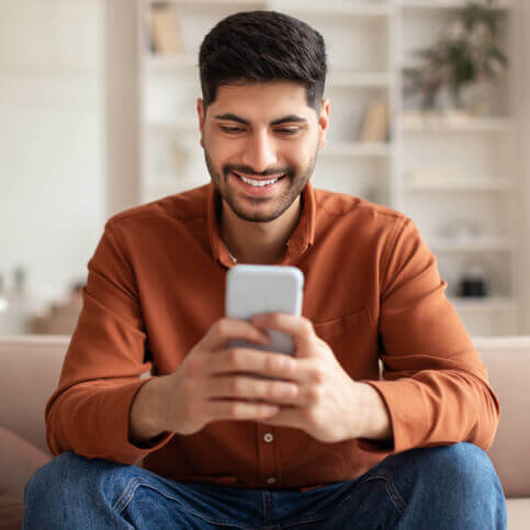 A man smiling at his phone
