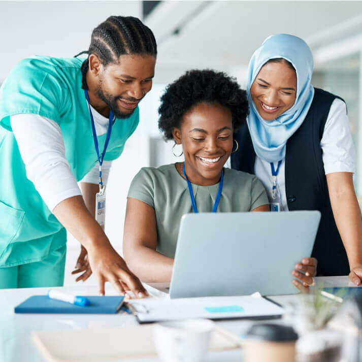 Medical professionals gathering around a laptop