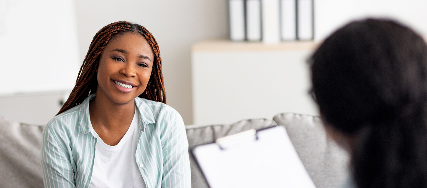 A woman smiling at another woman taking notes