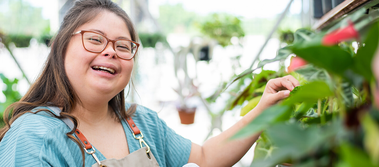A woman smiling while caring for plants