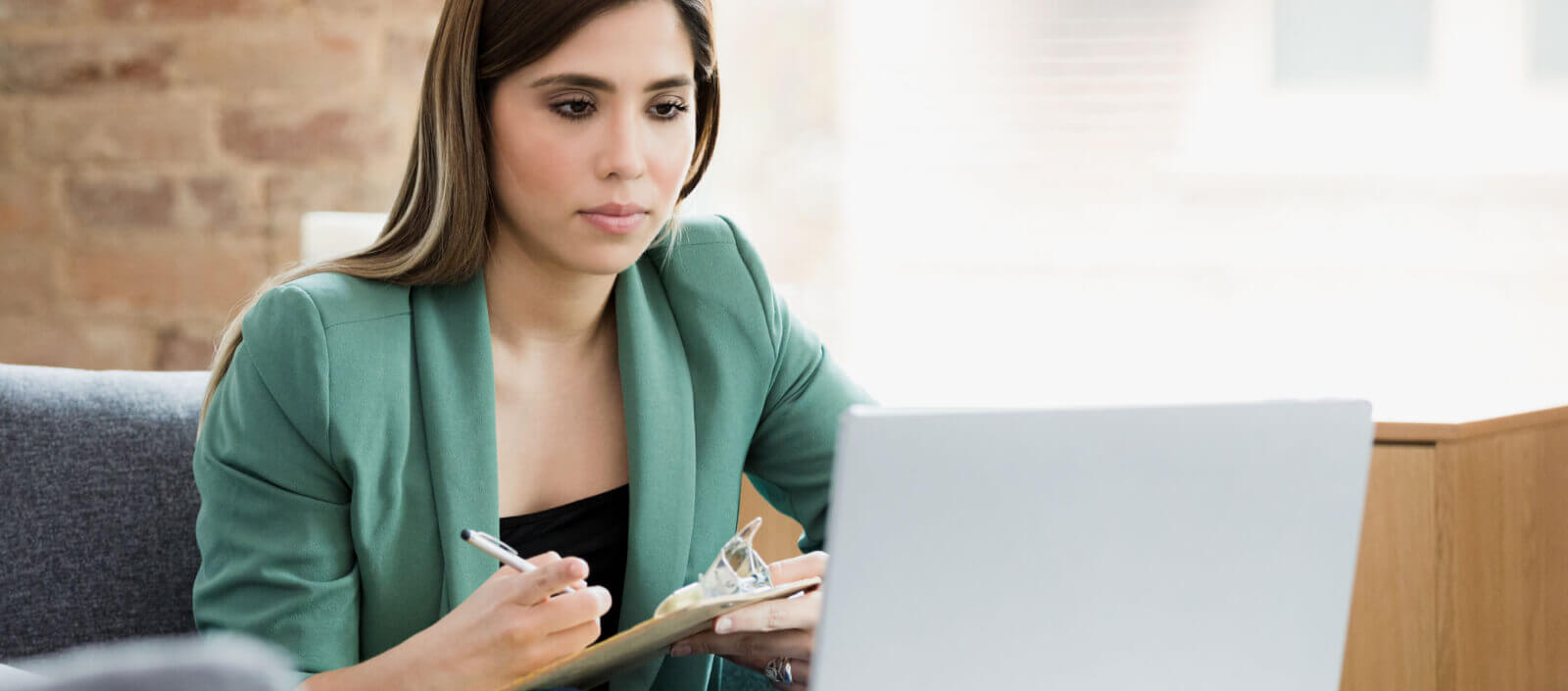 A women taking notes from a computer