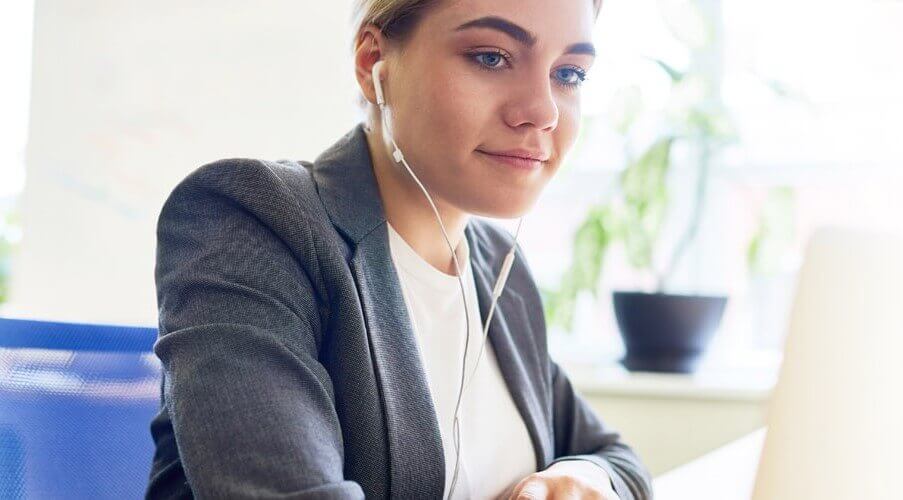 mental health professional wearing earbuds and watching the navigating asam webinar by qualifacts