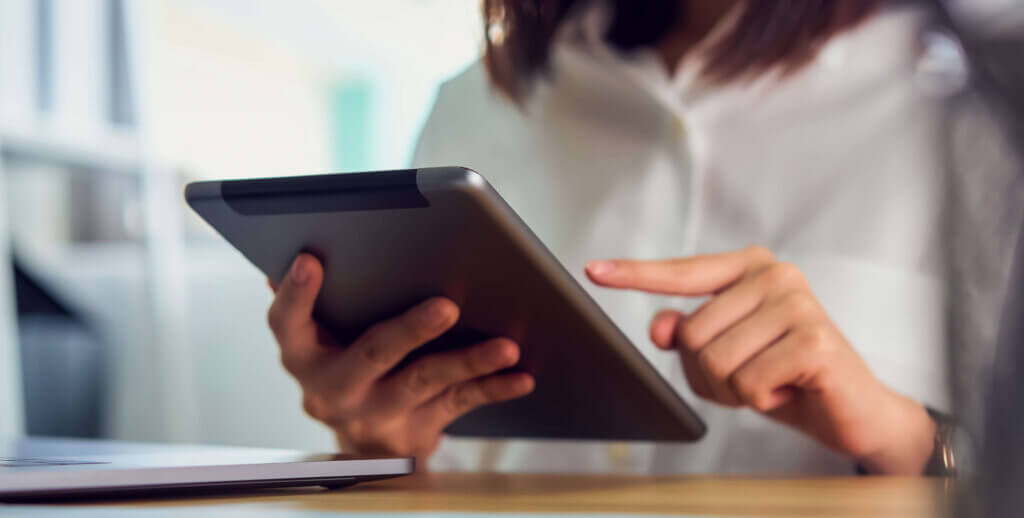 woman using a tablet to update patient records