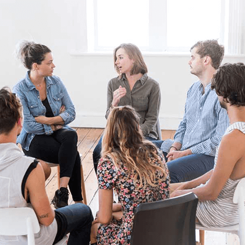 A group of people talking while sitting in a circle