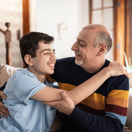 A young man hugging an older man