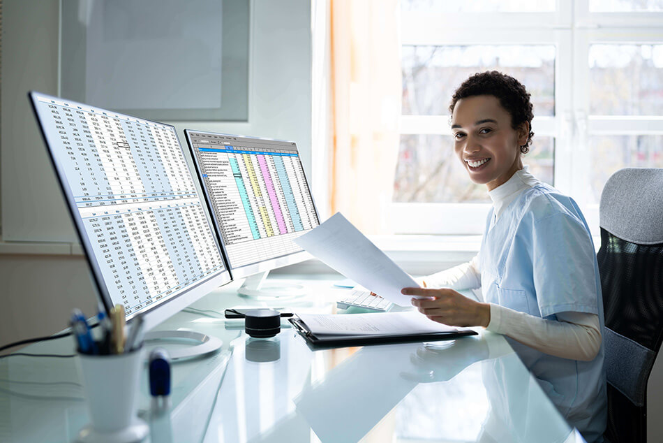 mental health professional sitting in front of a computer viewing her healthcare practice revenue cycle charts