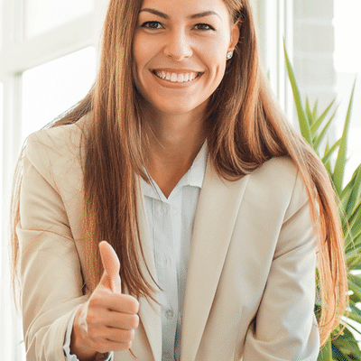A women smiling with a thumbs up